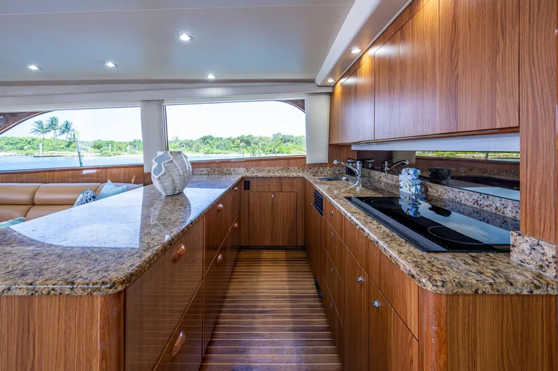 Adrian & Leidiana Yacht Photos Pics Luxurious 2005 Viking 61 yacht kitchen with granite countertops and wooden cabinetry.