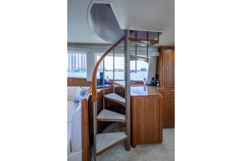 Adrian & Leidiana Yacht Photos Pics Interior of 2005 Viking 61 yacht with spiral staircase and wooden cabinetry.
