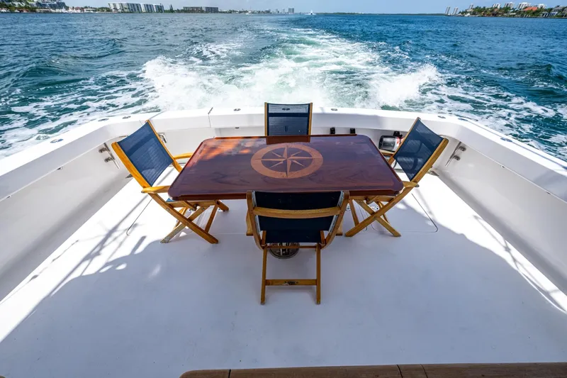 Adrian & Leidiana Yacht Photos Pics 2005 Viking 61 yacht deck with wooden table and chairs, ocean view.