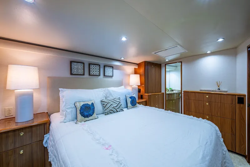 Adrian & Leidiana Yacht Photos Pics Luxurious bedroom interior of 2005 Viking 61 yacht with elegant decor and soft lighting.