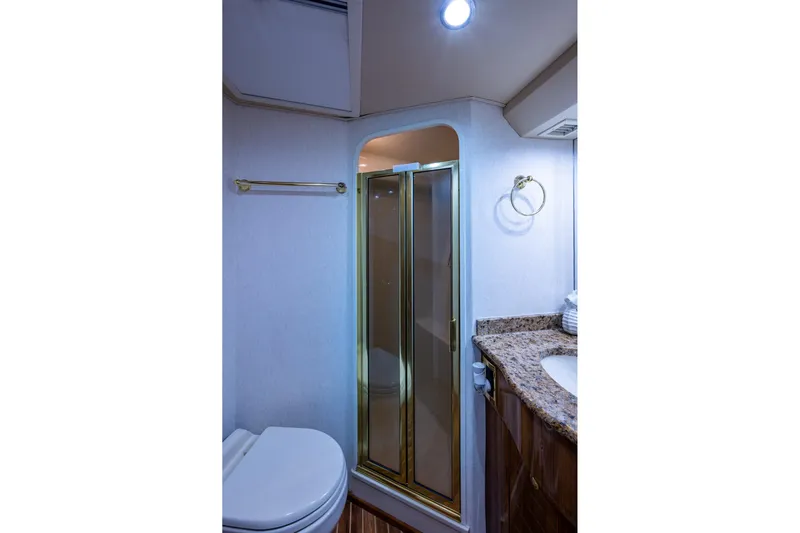 Adrian & Leidiana Yacht Photos Pics Luxurious bathroom in 2005 Viking 61 yacht with shower, granite countertop, and modern fixtures.