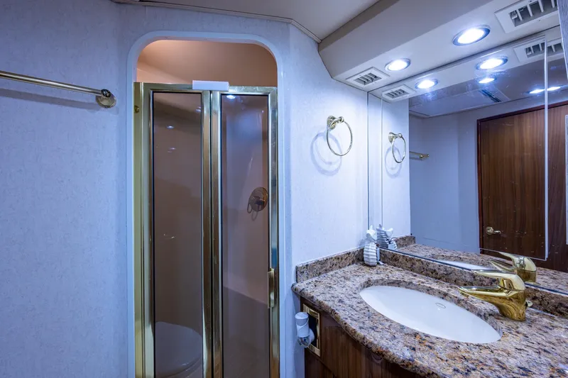 Adrian & Leidiana Yacht Photos Pics Luxurious bathroom in 2005 Viking 61 yacht with granite countertop and glass shower.