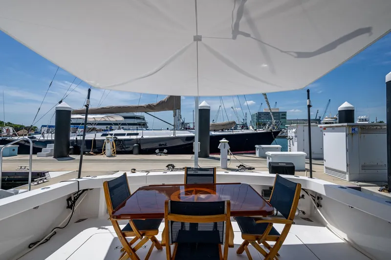 Adrian & Leidiana Yacht Photos Pics Outdoor seating on a 2005 Viking 61 yacht, docked at a marina under a sunshade.