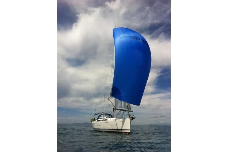 Panopaea Yacht Photos Pics Sailing yacht Dufour 405 GL 2011 with blue spinnaker on open sea under cloudy sky.