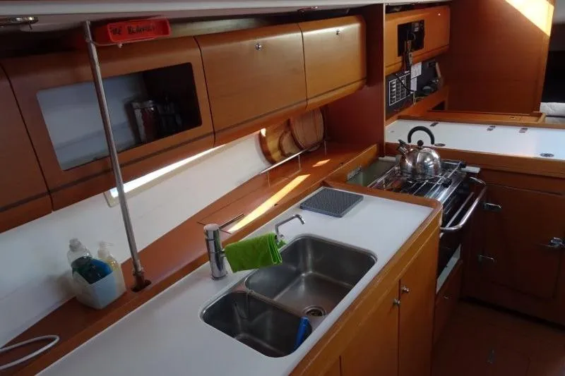 Panopaea Yacht Photos Pics 2011 Dufour 405 GL yacht kitchen with wooden cabinets and stainless steel sink.