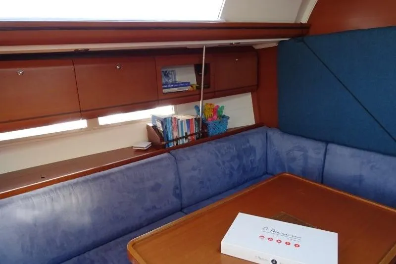 Panopaea Yacht Photos Pics Interior of 2011 Dufour 405 GL yacht with blue seating and wooden cabinetry.