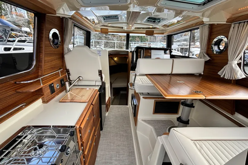  Yacht Photos Pics Luxurious interior of 2026 Ranger Tugs R-27 boat with wood finishes and modern amenities.