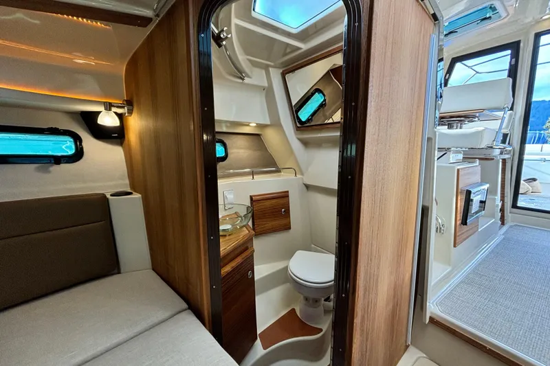  Yacht Photos Pics 2026 Ranger Tugs R-27 interior featuring a compact bathroom and cozy seating area.