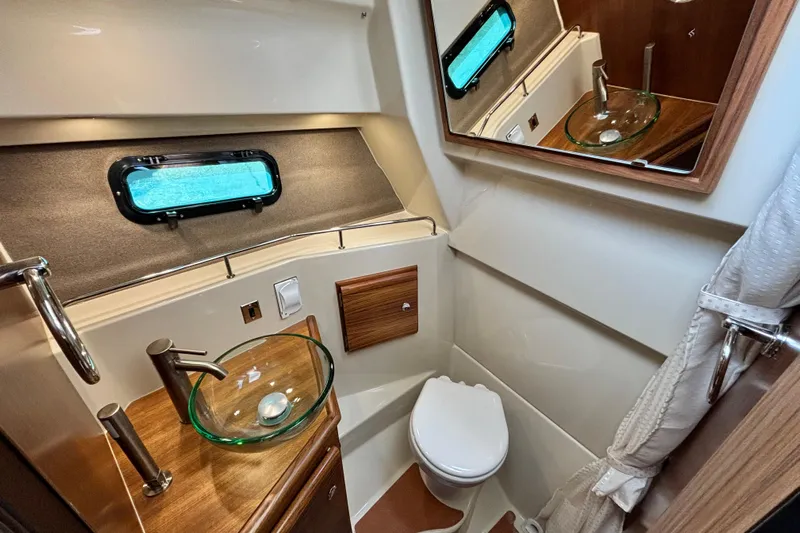  Yacht Photos Pics 2026 Ranger Tugs R-27 bathroom with modern fixtures and porthole window.
