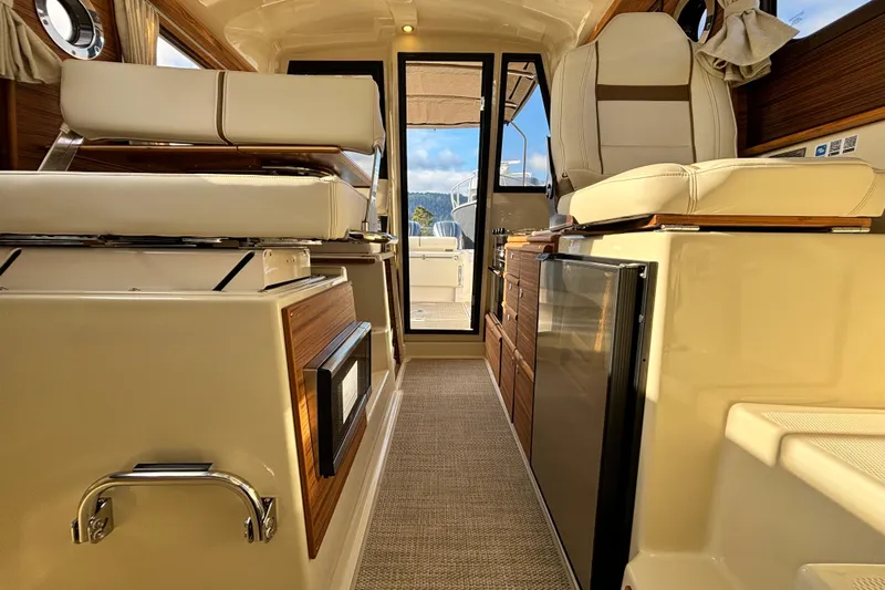  Yacht Photos Pics Interior of 2026 Ranger Tugs R-27 boat, featuring modern seating and cabinetry.
