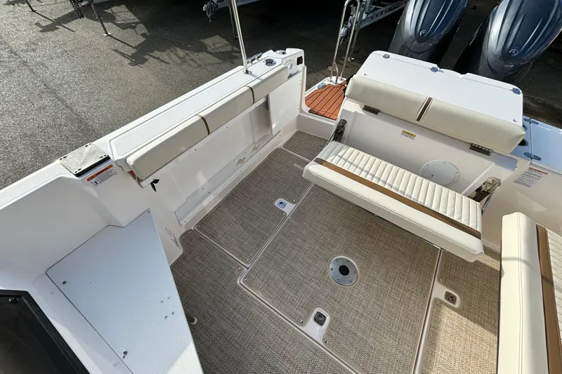  Yacht Photos Pics 2026 Ranger Tugs R-27 boat interior with cushioned seating and carpeted flooring.