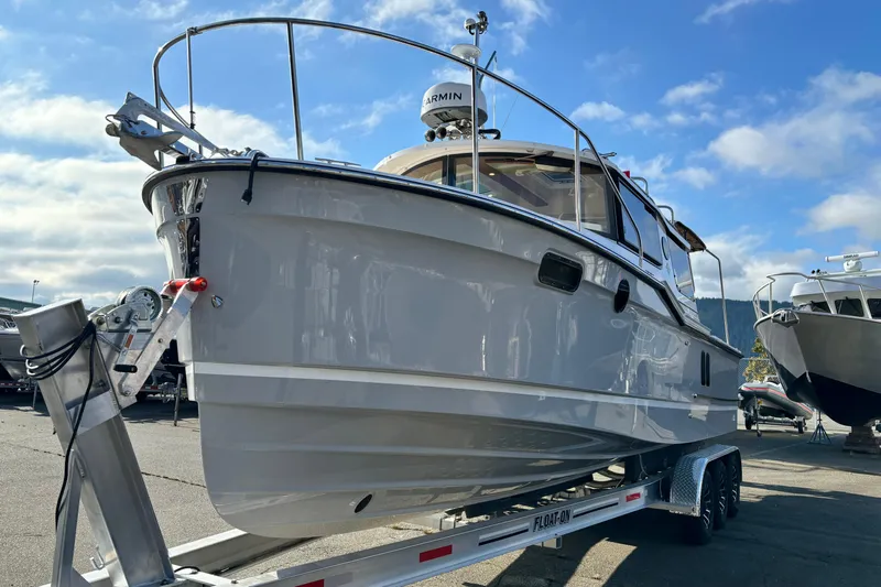  Yacht Photos Pics 2026 Ranger Tugs R-27 boat on trailer under clear blue sky.