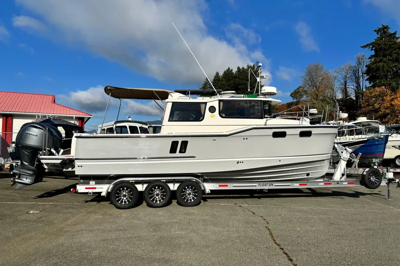  Yacht Photos Pics 2026 Ranger Tugs R-27 boat on trailer, parked outdoors under blue sky.