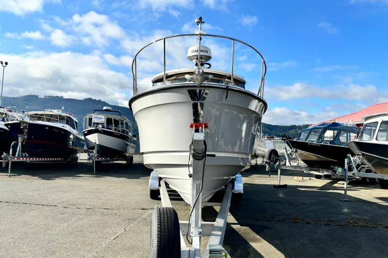  Yacht Photos Pics 2026 Ranger Tugs R-27 boat on trailer, surrounded by other boats, under a blue sky.