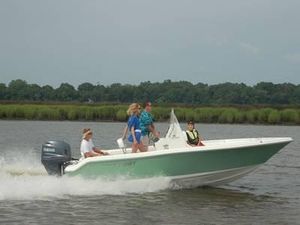 2014 Key West 189FS boat cruising on a river with passengers.