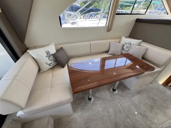 Melody Rose Yacht Photos Pics Interior of 2016 Carver C34 Command Bridge with plush seating and wooden table.