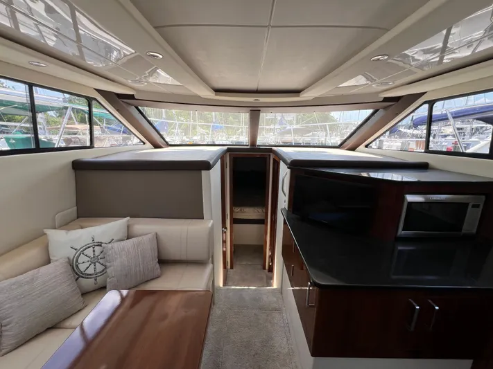 Melody Rose Yacht Photos Pics Interior of 2016 Carver C34 Command Bridge yacht with seating, table, and kitchenette.