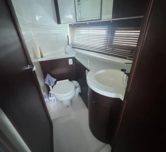 Knot Guilty Yacht Photos Pics Bathroom interior of 2016 Galeon 380 Fly yacht with modern fixtures and wooden accents.