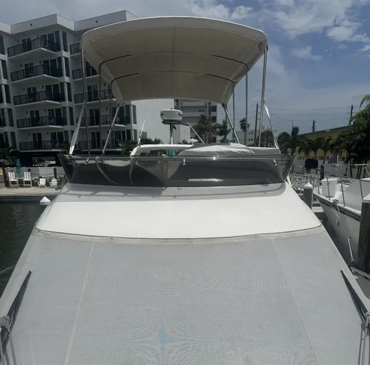Knot Guilty Yacht Photos Pics 2016 Galeon 380 Fly yacht docked near modern buildings under a cloudy sky.