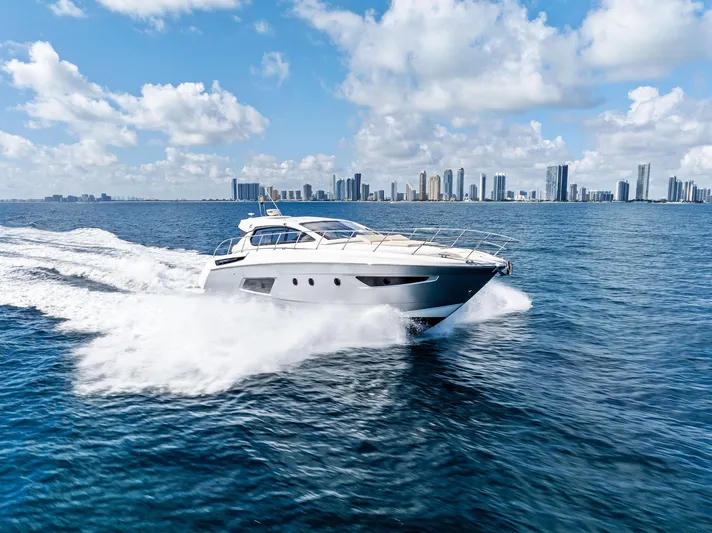 Manik Yacht Photos Pics Azimut Atlantis 50 yacht cruising on ocean with city skyline in background, 2016 model.