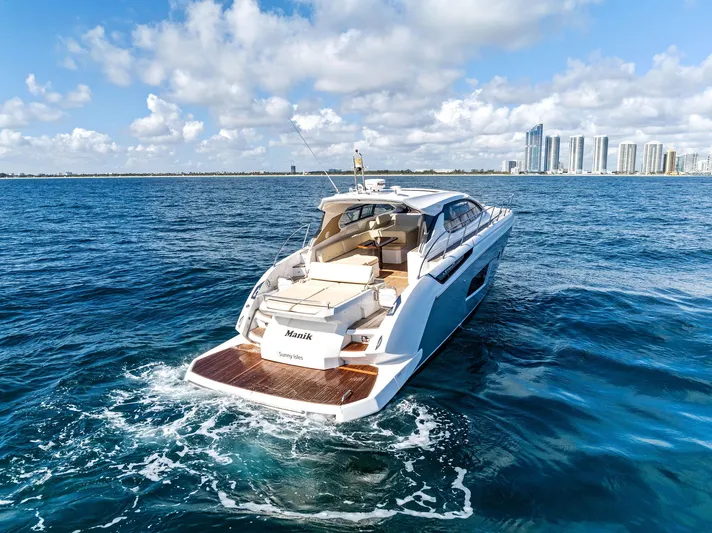 Manik Yacht Photos Pics Azimut Atlantis 50 yacht cruising on ocean, 2016 model, with city skyline in background.