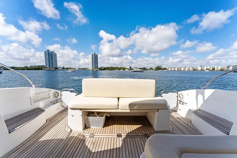 Manik Yacht Photos Pics Azimut Atlantis 50 yacht deck with seating, overlooking a scenic waterfront view.