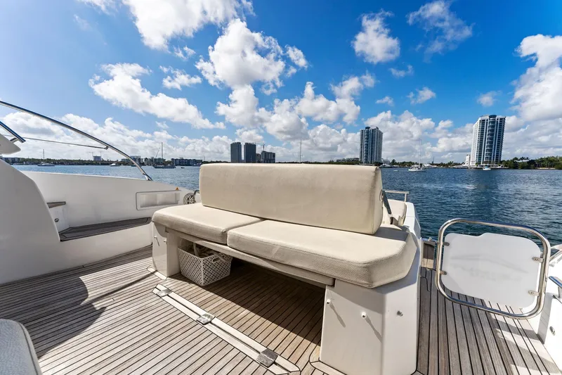 Manik Yacht Photos Pics Azimut Atlantis 50 yacht deck with seating, overlooking a city skyline and water.