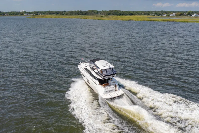  Yacht Photos Pics 2017 Sea Ray Fly 510 yacht cruising on open water, surrounded by scenic landscape.