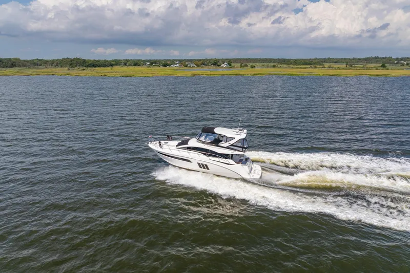  Yacht Photos Pics 2017 Sea Ray Fly 510 yacht cruising on open water under a partly cloudy sky.