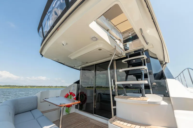  Yacht Photos Pics 2017 Sea Ray Fly 510 yacht with outdoor seating and staircase, docked on a sunny day.