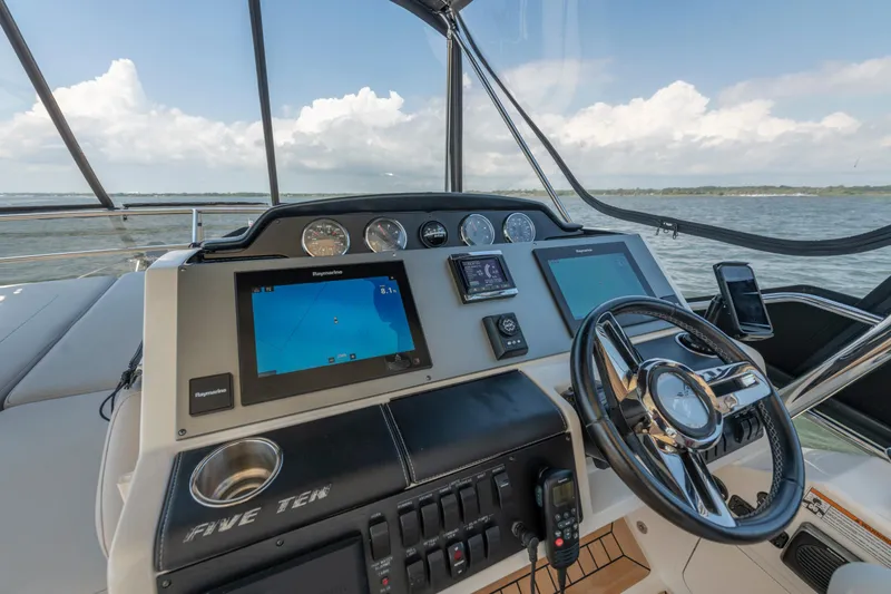  Yacht Photos Pics 2017 Sea Ray Fly 510 helm with navigation screens and steering wheel, overlooking the ocean.