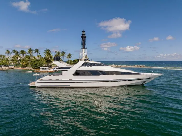 Entourage Yacht Photos Pics 1994 Norship Pilot House yacht cruising near a lighthouse and palm trees.