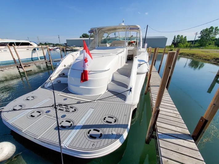  Yacht Photos Pics 1997 Sea Ray 580 Super Sun Sport yacht docked, featuring spacious deck and Canadian flag.