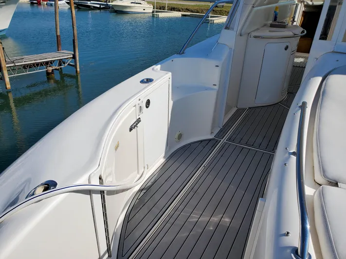  Yacht Photos Pics 1997 Sea Ray 580 Super Sun Sport yacht deck with sleek white design and wood flooring.