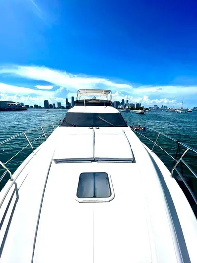  Yacht Photos Pics 2001 Azimut 58 yacht cruising on a sunny day with city skyline in the background.