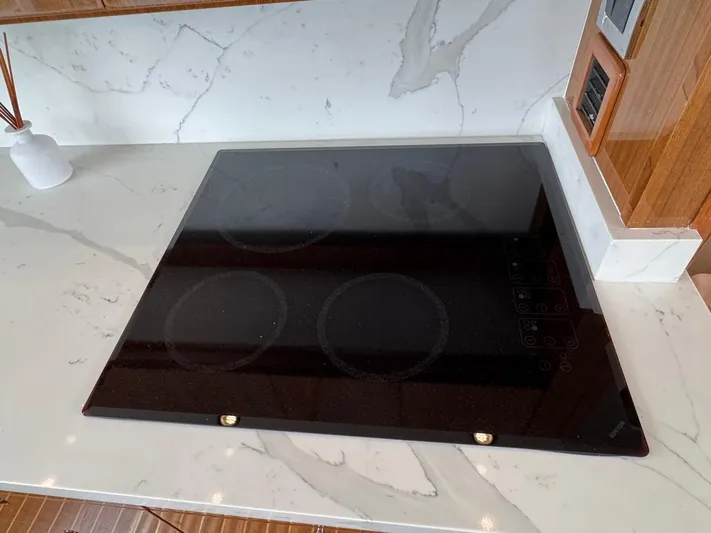  Yacht Photos Pics Glass cooktop on marble countertop in 2007 Viking 52 Convertibles yacht kitchen.