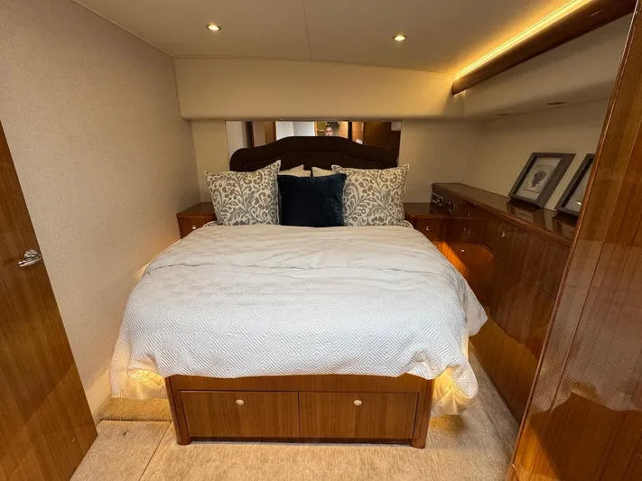  Yacht Photos Pics Luxurious bedroom interior of 2007 Viking 52 Convertibles yacht with elegant wood finish.