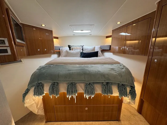  Yacht Photos Pics Luxurious bedroom interior of 2007 Viking 52 Convertibles yacht with elegant wood cabinetry.