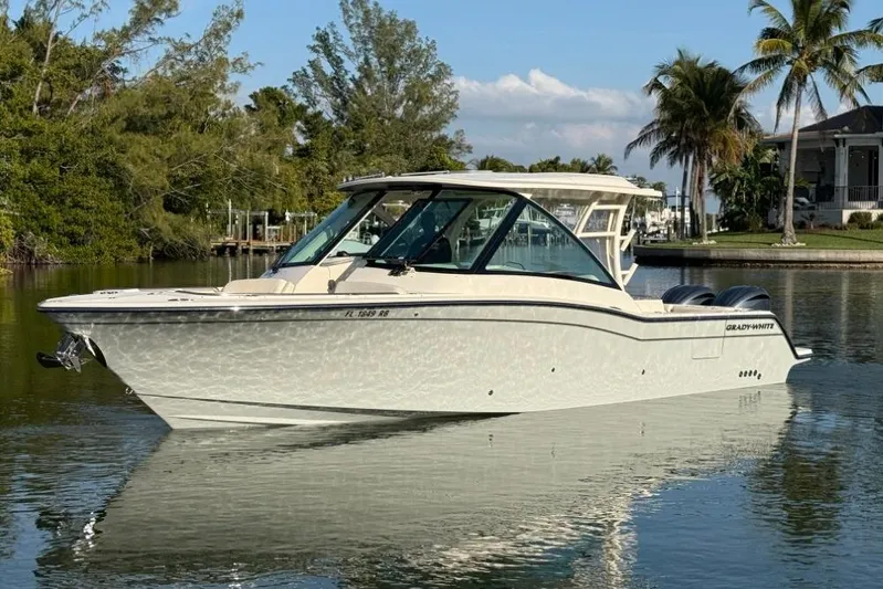  Yacht Photos Pics 2023 Grady-White Freedom 325 boat on calm water, surrounded by tropical scenery.
