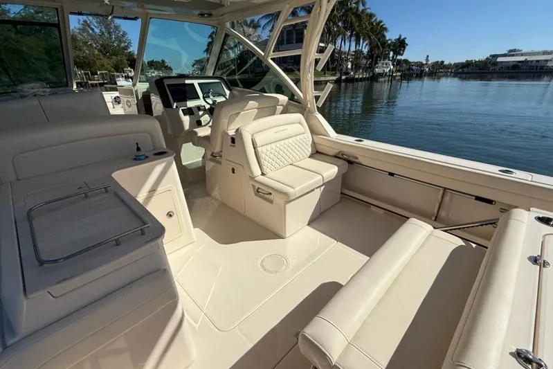  Yacht Photos Pics 2023 Grady-White Freedom 325 boat interior with luxurious seating and helm, docked by water.