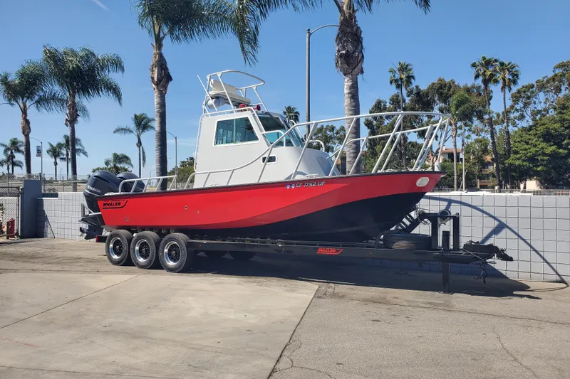  Yacht Photos Pics 1989 Boston Whaler Challenger boat on trailer, parked near palm trees.