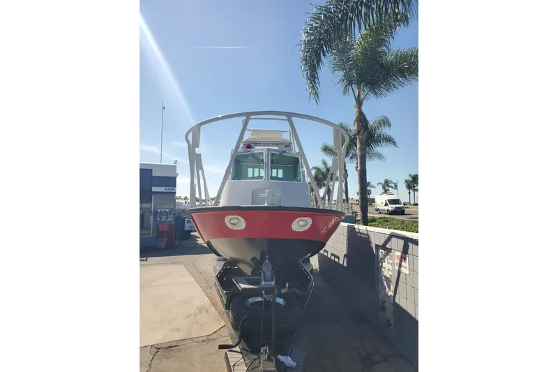  Yacht Photos Pics 1989 Boston Whaler Challenger boat on trailer, sunny day, palm trees in background.