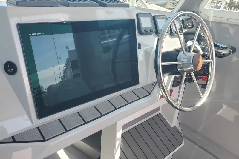  Yacht Photos Pics 1989 Boston Whaler Challenger helm with modern navigation equipment and steering wheel.