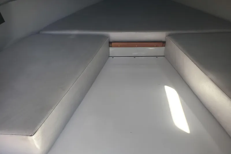  Yacht Photos Pics Interior cabin of a 1989 Boston Whaler Challenger boat with cushioned seating.