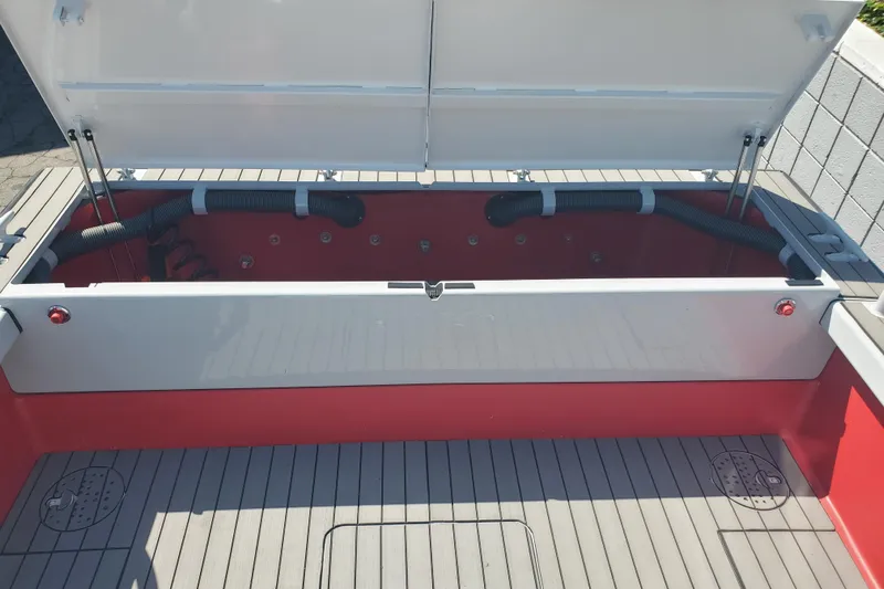  Yacht Photos Pics 1989 Boston Whaler Challenger boat interior with open storage compartment and visible hoses.