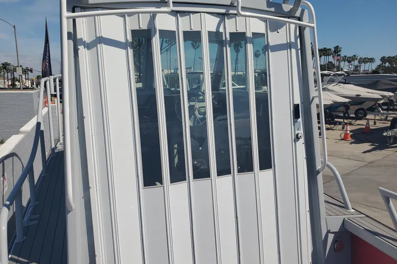  Yacht Photos Pics 1989 Boston Whaler Challenger boat with enclosed cabin, docked at a marina.