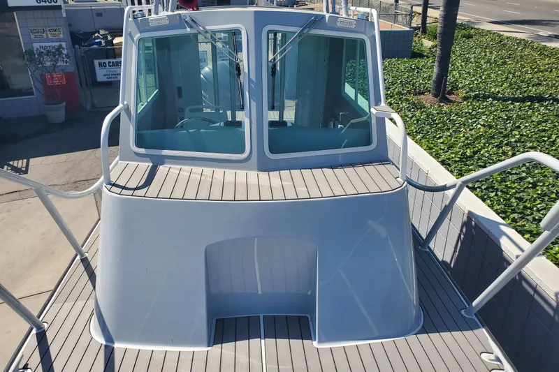  Yacht Photos Pics 1989 Boston Whaler Challenger boat deck with cabin view, docked outdoors.
