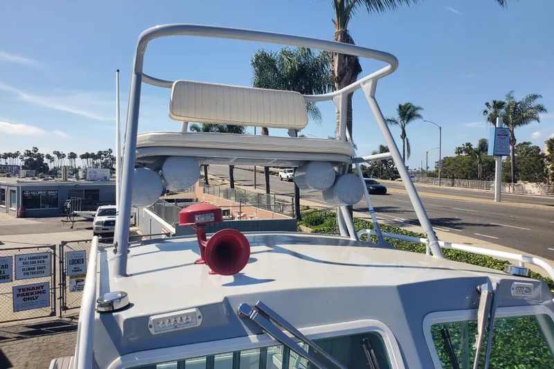  Yacht Photos Pics 1989 Boston Whaler Challenger boat with tower and horn, parked near a marina.