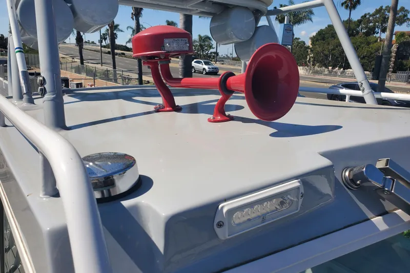  Yacht Photos Pics 1989 Boston Whaler Challenger boat with red horn on deck, parked near palm trees.