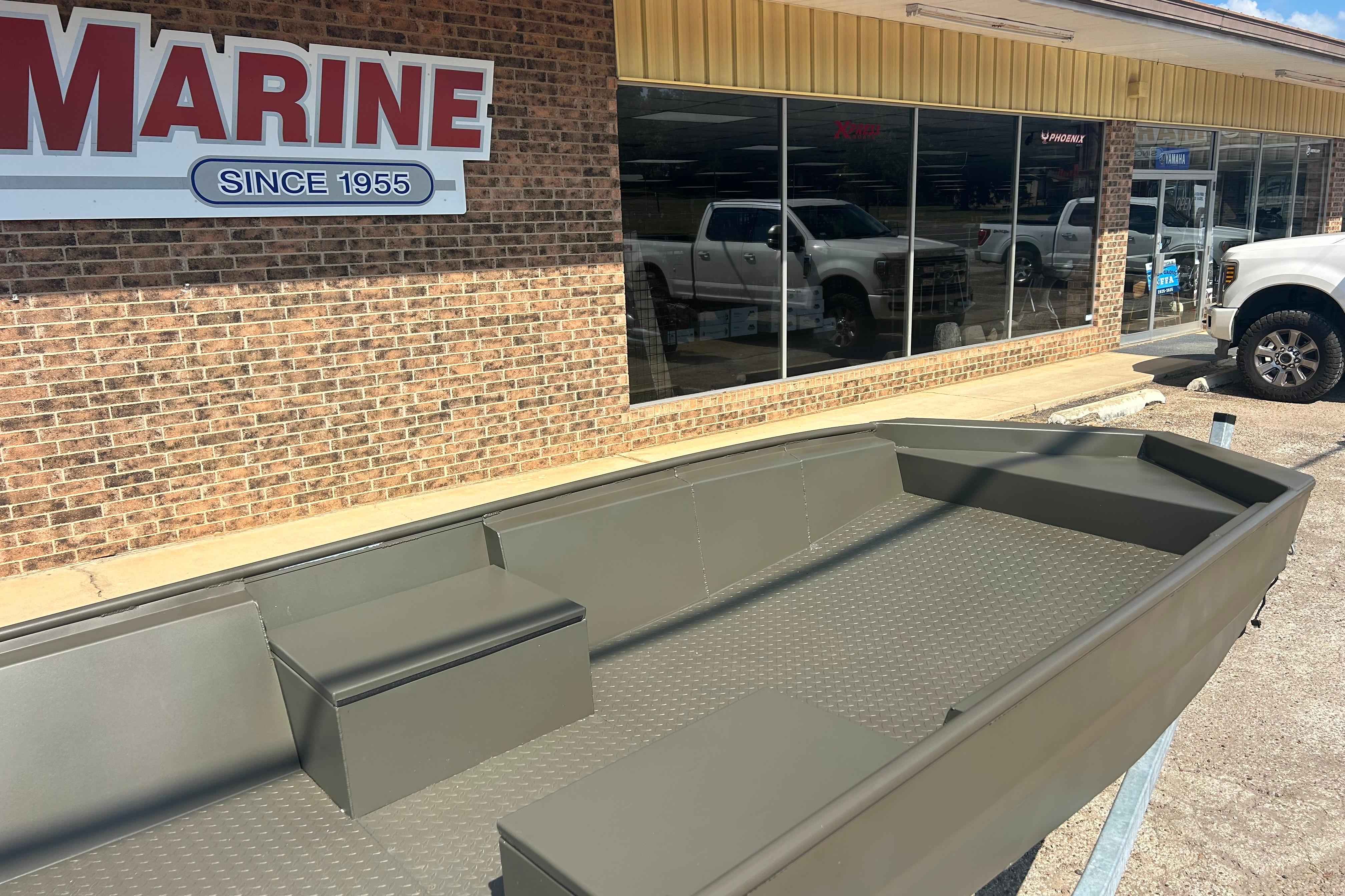 2025 WeldBilt 1652 boat displayed outside a marine store with brick facade.